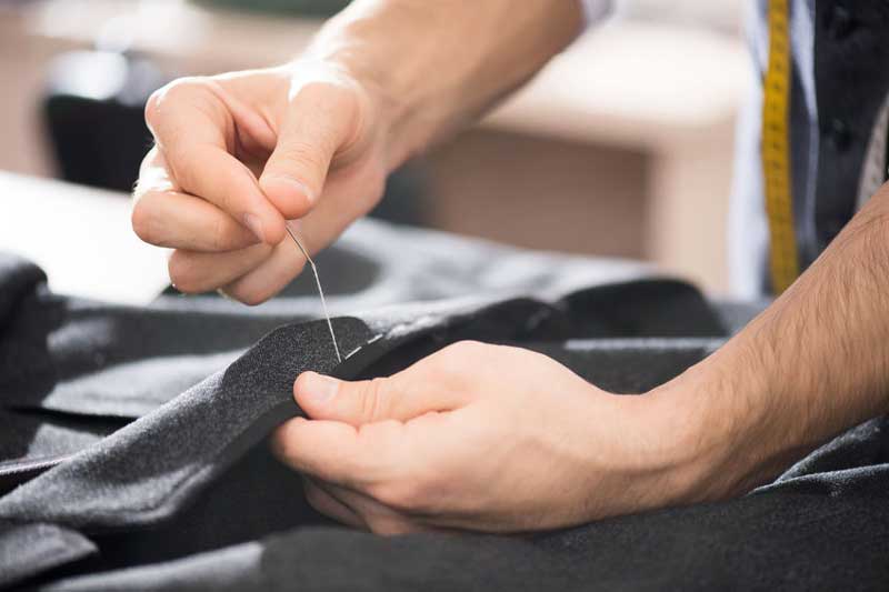 Man hand sewing clothes